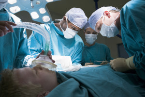 Three Surgeons Operating On A Patient